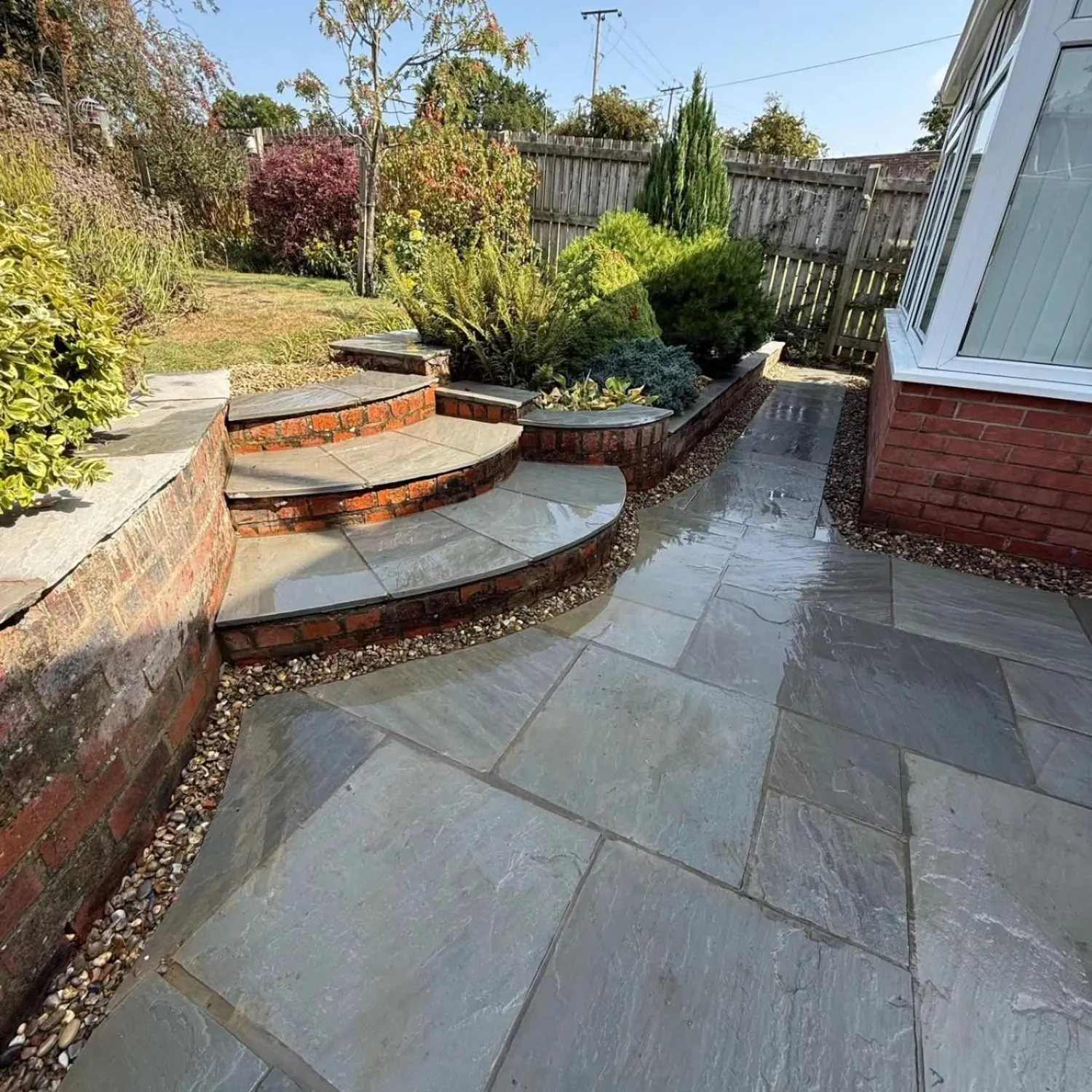 Completed stone paved terrace and curved garden steps